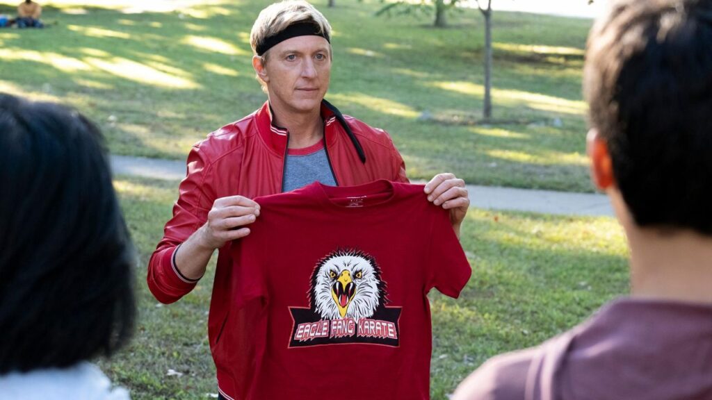 eagle-fang-karate-t-shirt-held-by-johnny-lawrence-william-zabka-in-cobra-kai-tv-show-season-3-episode-2