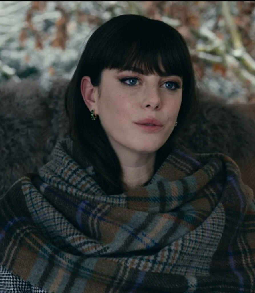 Kaya-Scodelario-wearing-a-gray-and-green-toned-wool-plaid-wrap-scarf-in-Season-1-Episode-2-of-The-Gentlemen-on-Netflix-TackleTommyWooWoo